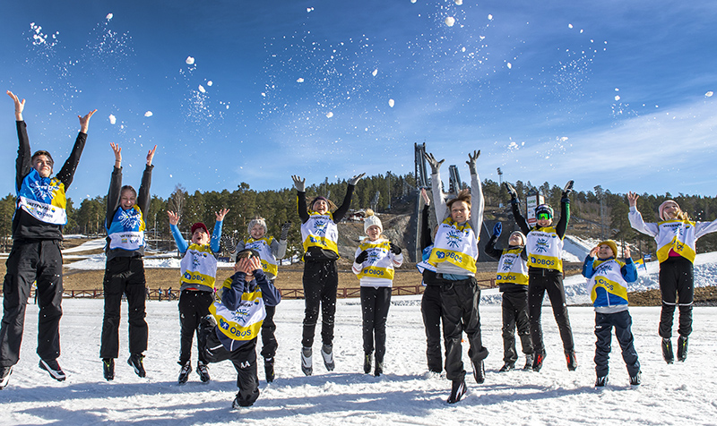 Alla på snö-ledare och barn kastar snö upp i luften. Foto: Trons.